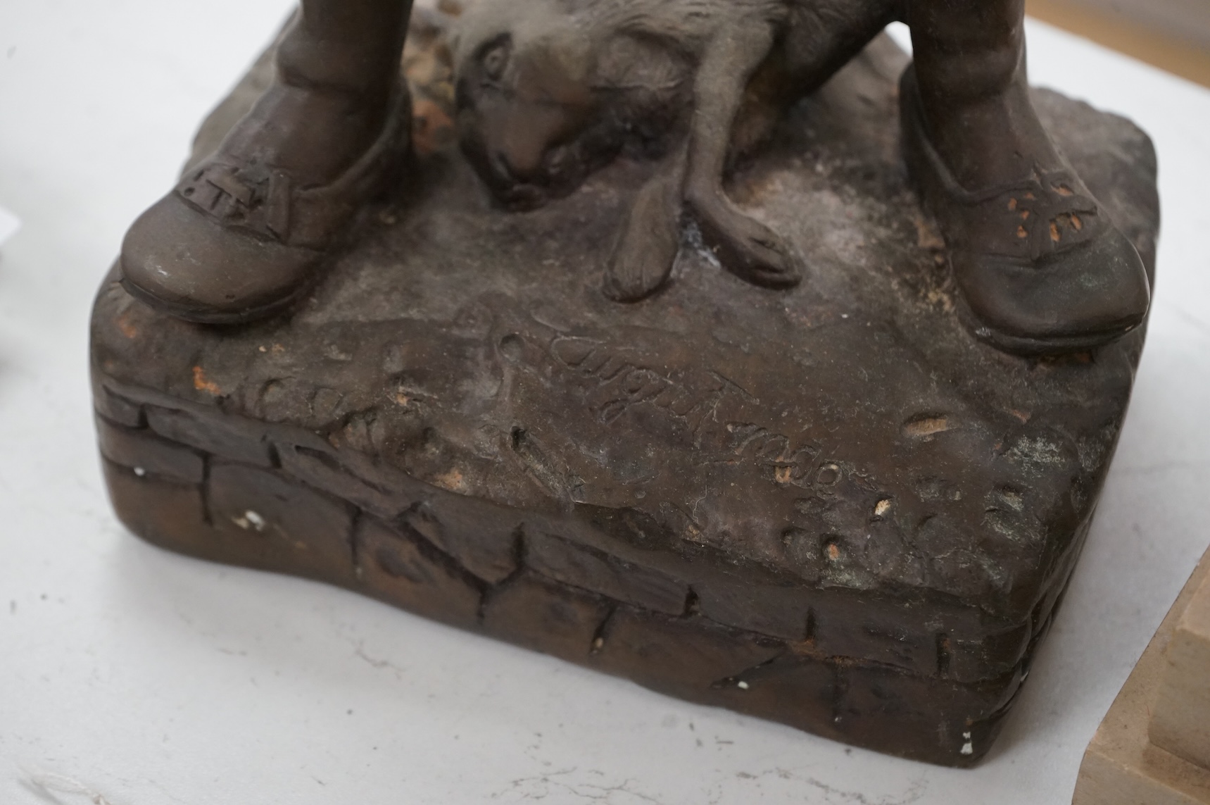 A bronze figure of a young boy carrying dead game, signed August, and a classic bronze of a young boy holding a fish, indistinctly signed, largest 53cm high